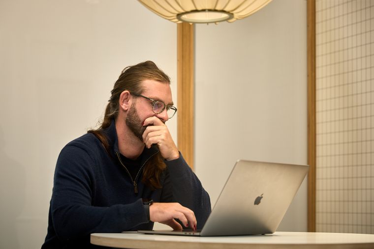 Person looking at a laptop, looking contemplatives