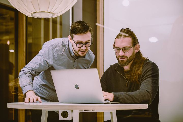 Two team members looking at a laptop