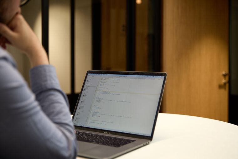 Person looking at a laptop screen with code