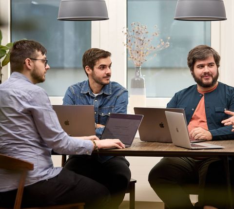 Three team members looking attentively to the side