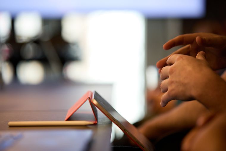 Hands gesturing in front of a smart phone