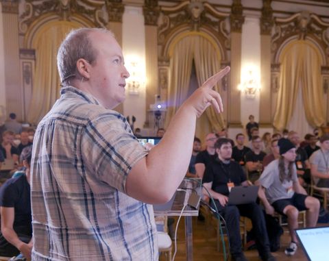 Team member speaking in front of a large audience at Emberfest 2021