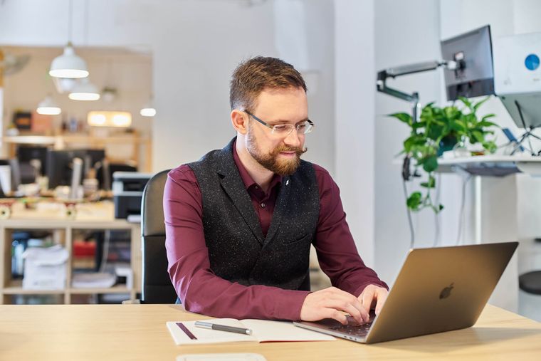 Team member smiling at a laptop