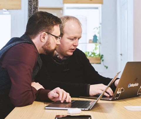 Two team members looking at a laptop